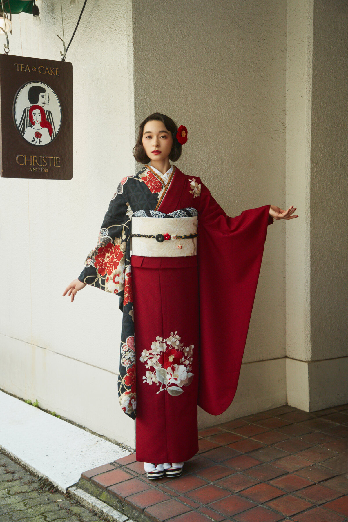 赤と黒の振袖をまとった女性の全身コーディネート