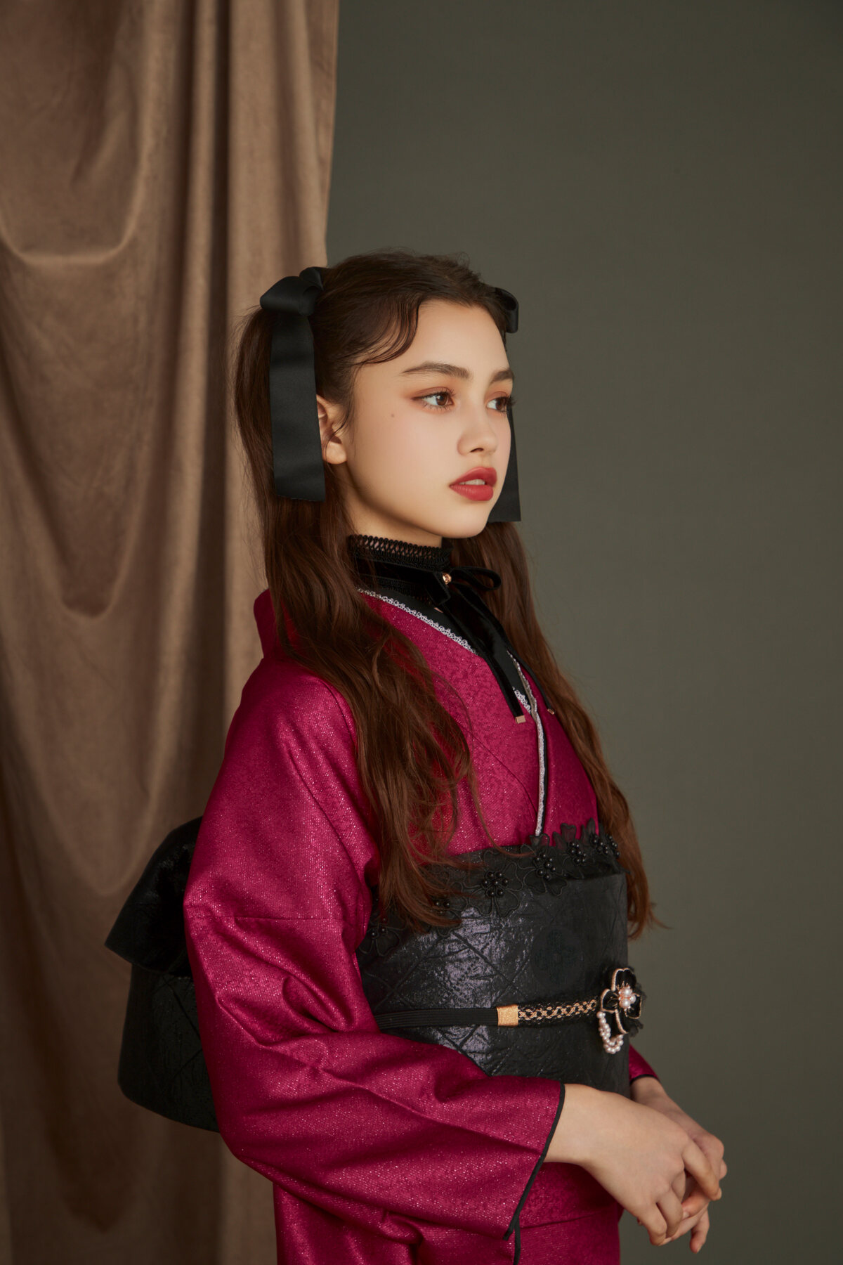 鮮やかなピンクの振袖に黒い帯を合わせた女性